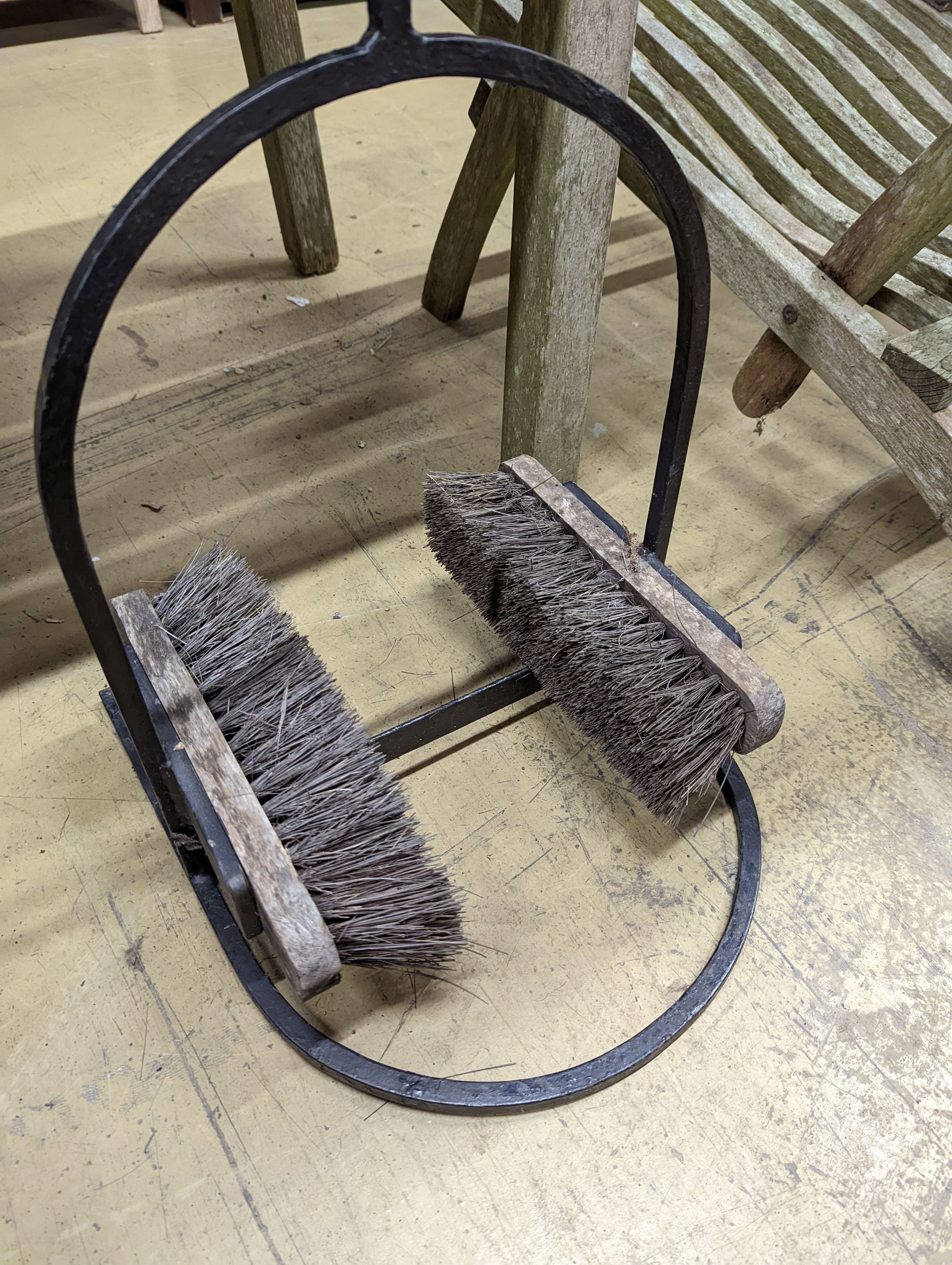 A wrought iron boot brush. H-90cm.